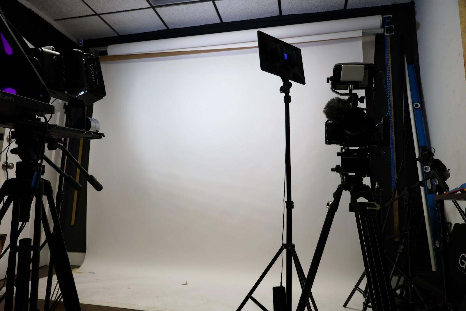 Video set with cameras and a white backdrop at Stars International